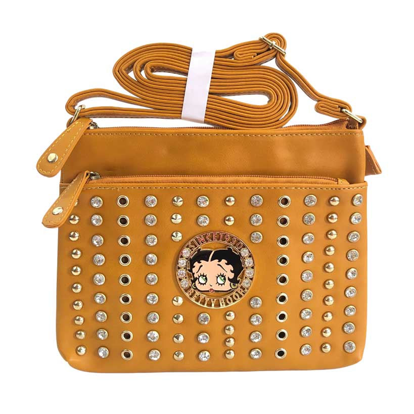 Mensajera Betty Boop de color mostaza, placa circular con imagen de Betty Boop en el centro, piedras decorativas de color dorado y piedras en cristal cortado y pulidas decorativas, Primer cierre de color mostaza oscuro y detalles dorados en la parte de enfrente, y un cierre principal en color mostaza oscuro y detalles dorados en la parte superior, asa ajustable del material cuero ecológico, el mismo del resto de la mensajera.