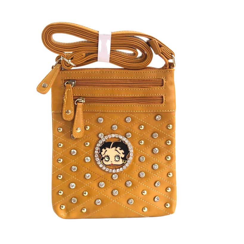 Mensajera Betty Boop de color mostaza, placa circular con imagen de Betty Boop en el centro, piedras decorativas de color dorado y piedras en cristal cortado y pulidas decorativas, dos primeros cierres de color mostaza oscuro y detalles dorados en la parte de enfrente, y un cierre principal en color mostaza oscuro y detalles dorados en la parte superior, asa ajustable del material cuero ecológico, el mismo del resto de la mensajera.